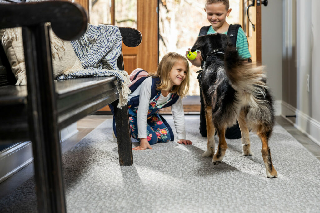 Kids playing with dog on carpet floors | Carpet Mart